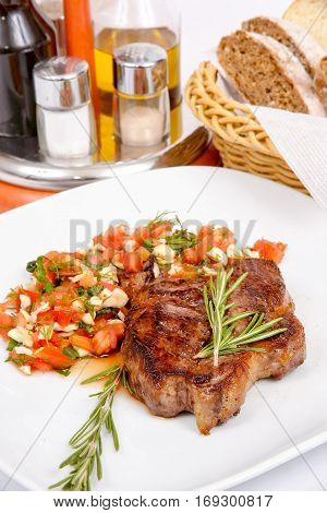 Grilled pork with tomato sauce garlic and rosemary on a white plate with spices