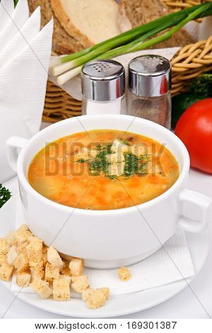 Pea soup with croutons in the white plate with greens