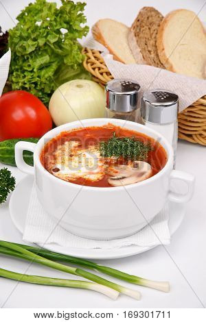 Ukrainian borsch with mushrooms and sour cream on a white plate