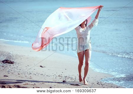 Happy woman enjoying beach relaxing joyful in summer by tropical blue water.