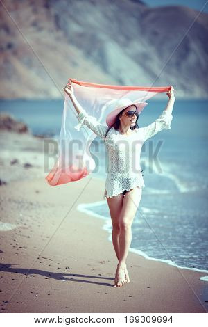 Happy woman enjoying beach relaxing joyful in summer by tropical blue water.