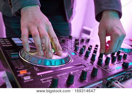 DJ plays and mix music on digital midi mixer controller.