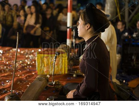 Hanoi, Vietnam - Nov 2, 2014: Side portrait of Vietnamese artist perform folk music and song on Ma May st, old town of Hanoi. The show is free for tourist every night