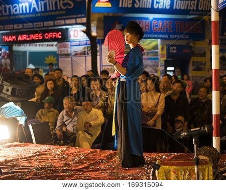 Hanoi, Vietnam - Nov 2, 2014: Dancer with red fan and old traditional clothes performs ancient dance of folk music and song. The show is free for tourist every night in old quarter of Hanoi