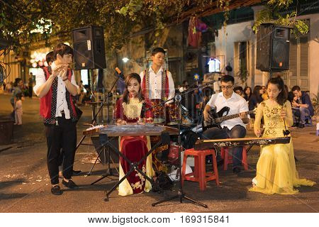 Hanoi, Vietnam - Nov 2, 2014: Vietnamese traditional folk band perform on Ma May street at night, old quarter of Hanoi