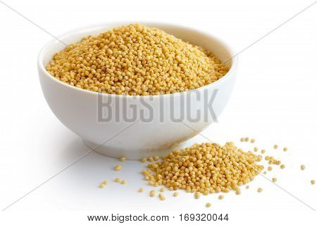 Dry Millet In White Ceramic Bowl Isolated On White. Spilled Millet.