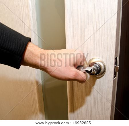 The person opens an wooden interroom door