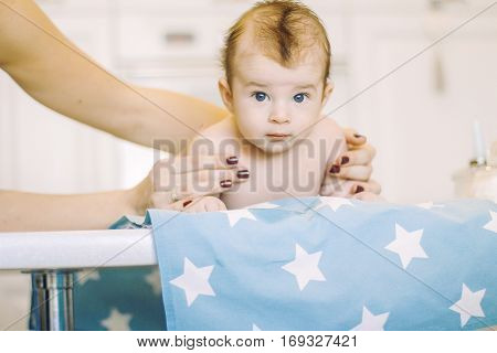 small child learns to help parents keep his head. baby lying on a blue diaper in a star. parental support.