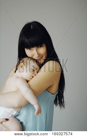 little baby asleep in the arms of his mother. cute child, happy mother
