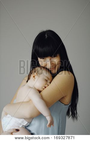little baby asleep in the arms of his mother. cute child, happy mother