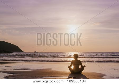 The practice of yoga on the beach at dawn during low tide .Time for peace of mind. Alone with nature. Connection with the universe.