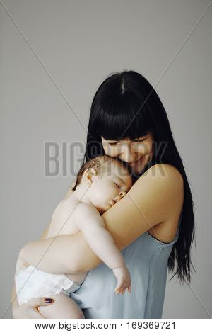 little baby asleep in the arms of his mother. cute child, happy mother