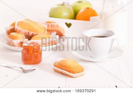 Breakfast with plumcake and apricot jam on white dish.