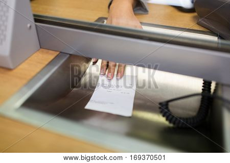 people and finance concept - clerk giving receipt at bank office or currency exchanger