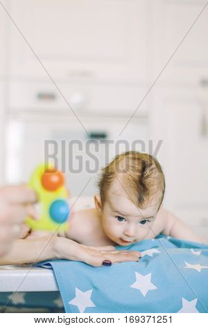 small child learns to help parents keep his head. baby lying on a blue diaper in a star. parental support.