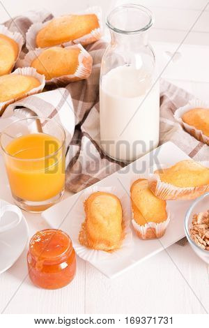 Breakfast with plumcake and apricot jam on white dish.