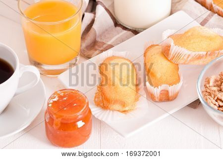 Breakfast with plumcake and apricot jam on white dish.