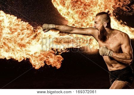 Professional fighter shadowboxing with fire and sparks on background