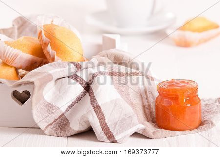Breakfast with plumcake and apricot jam on white dish.