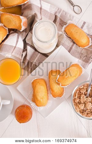 Breakfast with plumcake and apricot jam on wooden table.