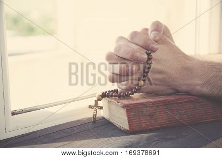 man hand cross on the book on winodow