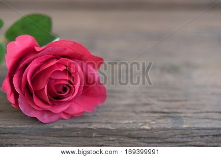 Red rose petal closeup on wooden rustic table with copy spce