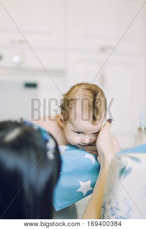 small child learns to help parents keep his head. baby lying on a blue diaper in a star. parental support.