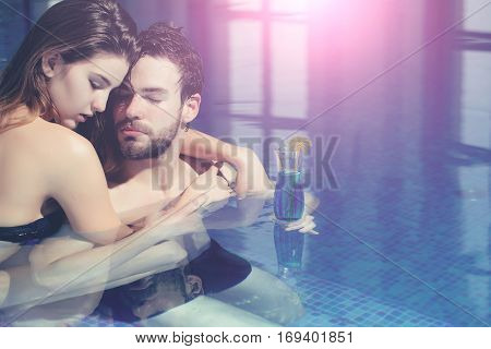 Muscular Man And Sexy Woman In Blue Pool With Cocktail