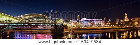 Moscow Russia - January 20 2017: Night winter panorama of the Moskva River embankment: pedestrian bridge Bogdan Khmelnitsky Kiyevskaya railway station Moscow-City Redisson Slavyanskaya hotel 