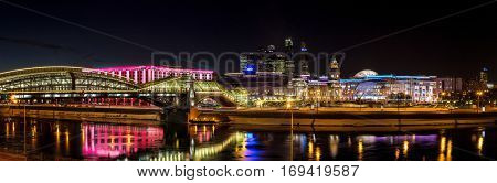 Moscow Russia - January 20 2017: Night winter panorama of the Moskva River embankment: pedestrian bridge Bogdan Khmelnitsky Kiyevskaya railway station Moscow-City Redisson Slavyanskaya hotel 