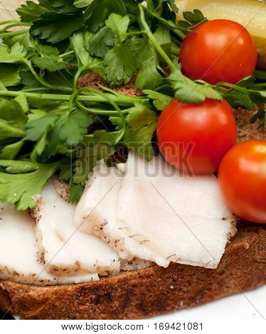Lard on bread tomatoes and fresh herbs on the table