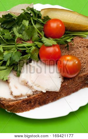 Lard on bread tomatoes and fresh herbs on the table