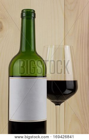 bottle of red wine with a brilliant glass on a wooden background
