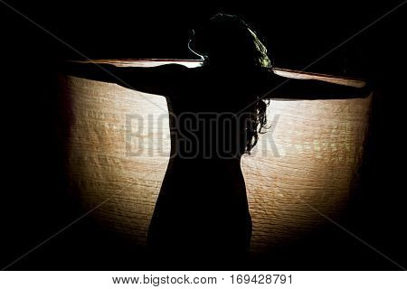 Silhouette of woman in backlight behind a kerchief