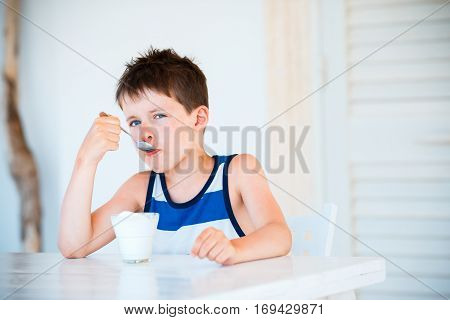 Portrait of cute little boy refuses to eat delicious yogurt