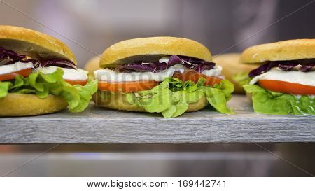 hamburger tris with salad cheese and tomato on the rock in a showcase ready to eat