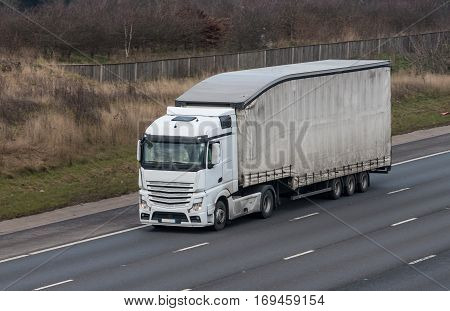 White lorry with tipping trailer in motion on the motorway