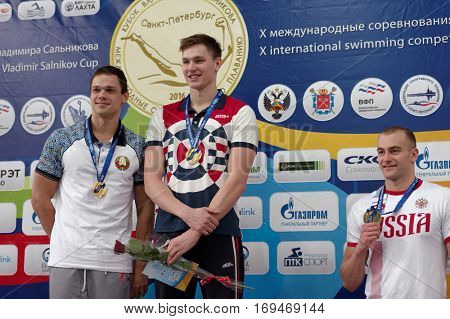 ST. PETERSBURG, RUSSIA - DECEMBER 16, 2016: Winners of X Salnikov Cup in 100 m freestyle swimming Alexander Kliukin of Russia (center), Artyom Machekin of Belarus (left) and Andrey Arbuzov of Russia