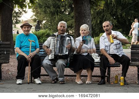 BELGRADE SERBIA - AUGUST 30 2015: Serbian old people celebrating playing accordeon and drinking local beer