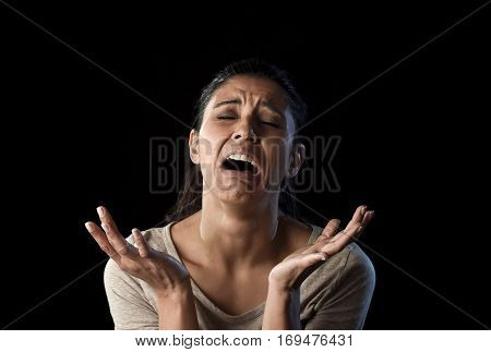 young attractive sad and desperate Latin woman crying frustrated suffering pain and problems grieving in stress and sorrow in facial expression of sadness emotion isolated on black background