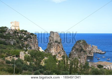 Top view of the rocks, medieval tower and Mediterranean ocean in Scopello Beach, Sicily, Italy