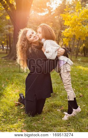 Mother With Daughter Seven Years Old In Autumn Park At Sunset