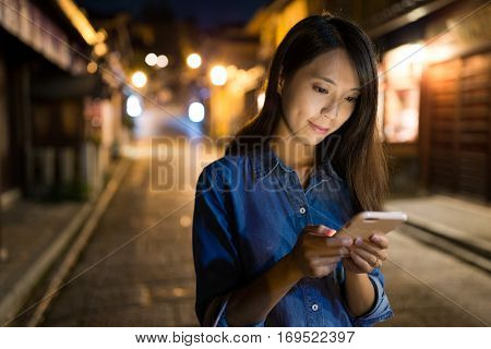 Woman looking at mobile phone at night