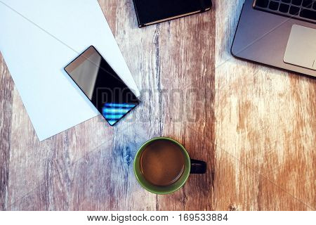 Coffee break time to take pause from your work - cup with hot coffee drink on office desk among smartphone and laptop computer
