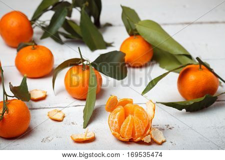 mandarins with leaves on white woodwn background.