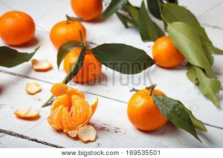 mandarins with leaves on white woodwn background.