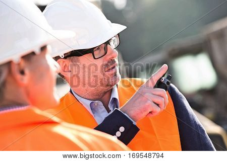 Supervisor showing something to colleague at construction site