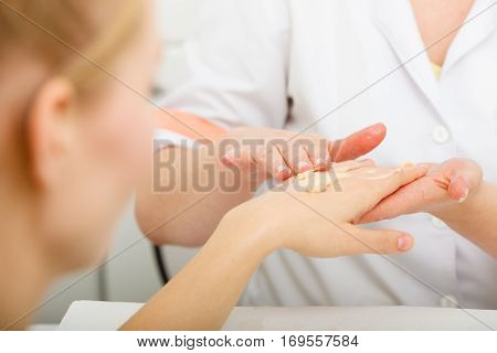 Handcare taking care of hands cosmetics concept. Woman applying cream on hand.