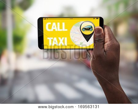 Male hand with smartphone on blurred road background. Taxi service application on screen.