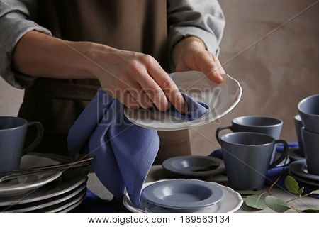 Closeup of female hands cleaning saucer